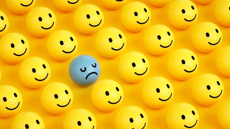 Billede af mange glade smileys og en der er ked af det